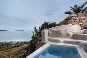 uma banheira sentada no topo de uma parede de pedra em Boheme Mykonos Town - Small Luxury Hotels of the World em Míconos