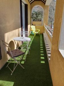 a room with a table and chairs on a balcony at Le lorrain in Saint-Pons-de-Thomières
