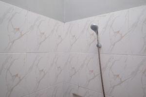 a shower with a shower head in a bathroom at RedDoorz Near Dr Oen Solo Baru Hospital in Klaten