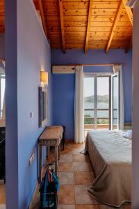 1 dormitorio con paredes azules, 1 cama y 1 mesa en Apelon Tiritas Villas, en Leonidio