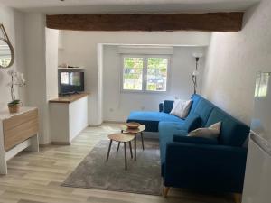 a living room with a blue couch and a table at Appartement centre ville en RDC in Lorgues