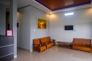 a room with two chairs and a tv on a wall at RedDoorz Near Dr Oen Solo Baru Hospital in Klaten +34 photos