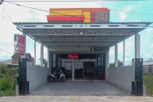 a gas station with a motorcycle parked under it at RedDoorz Near Dr Oen Solo Baru Hospital in Klaten