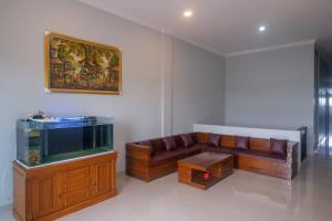 a living room with a couch and a fish tank at RedDoorz Near Dr Oen Solo Baru Hospital in Klaten