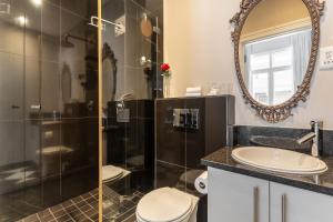 a bathroom with a shower and a toilet and a sink at Long Street Boutique Hotel in Cape Town +115 photos