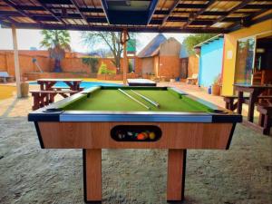 a pool table with two cues on top of it at Johannesburg Airport Hostel in Benoni