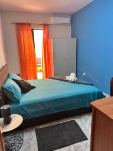 a bedroom with a large bed with an orange curtain at Marsaskala Sea Side Retreat in Marsaskala