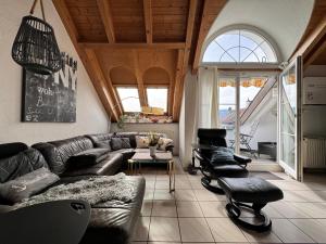 a living room with a leather couch and chairs at Casa Via Bodman-Ludwigshafen in Bodman-Ludwigshafen