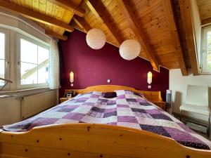 a wooden bed in a room with a purple wall at Casa Via Bodman-Ludwigshafen in Bodman-Ludwigshafen