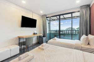 a hotel room with two beds and a television at Ployburi Boutique Hotel in Chanthaburi