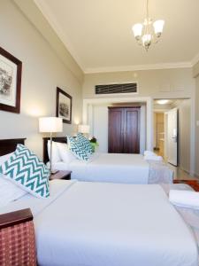 a hotel room with two beds and a couch at Albany Hotel in Durban
