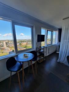 a room with a table and chairs and windows at Klaipėda city panoramic view in Klaipėda