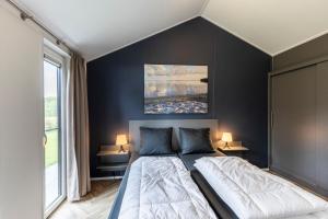 a bedroom with a large bed with black walls at Recreatiepark De Bosrand in Oudemirdum