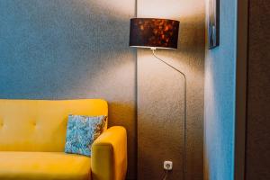 a yellow couch and a lamp in a room at HOTEL CIAO in Târgu-Mureş