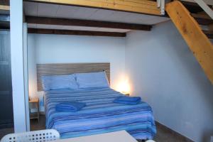 Un dormitorio con una cama con almohadas azules. en Aeolian Sea House, en Santa Marina Salina