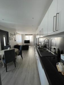 アラドにあるApartment 1 confort&modernの白いキャビネット付きのキッチン、リビングルーム