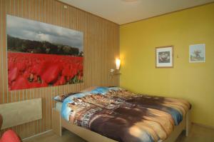 1 dormitorio con 1 cama con una pintura en la pared en Bed and Breakfast Tulip Gallery, en Ámsterdam