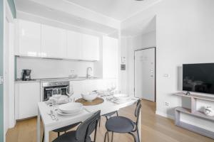 a white kitchen with a white table and chairs at SIL5 - Apartment Bright - Luxury in Milan