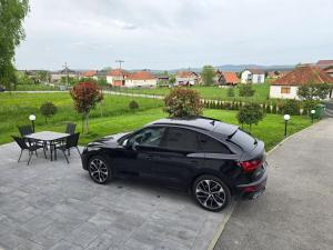 a black car parked in front of a table at Uvac lake "FF" in Sjenica