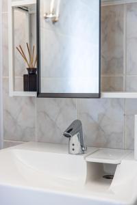 Un lavabo de baño con espejo y grifo. en Seaside apartments - Sunset apartment, en Klaipėda