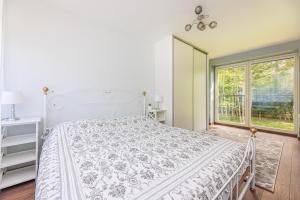 Una habitación blanca con una cama y una ventana en Seaside apartments - Sunset apartment, en Klaipėda