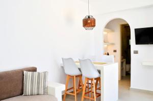 a living room with a couch and a table with stools at Lilian Studios in Koufonisia