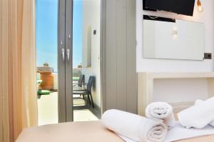 a room with towels on a table with a balcony at Lilian Studios in Koufonisia +107 photos