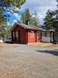 ein kleines rotes Haus mit Kieseinfahrt in der Unterkunft Holiday Home Samanitieva in Enontekiö