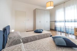 a bedroom with two beds and a large window at Casa Primo Maggio in Cerasolo