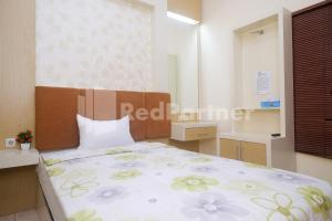 ein Schlafzimmer mit einem Bett in einem Zimmer mit einem Fenster in der Unterkunft Tatti Inn Syariah Seturan RedPartner in Yogyakarta
