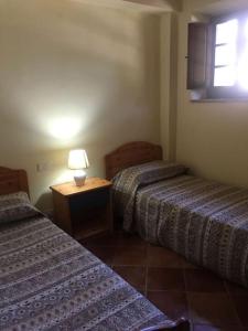 une chambre avec deux lits et une table avec une lampe dans l'établissement Cozy home in countryside Asciano Siena -renovated!, à Asciano