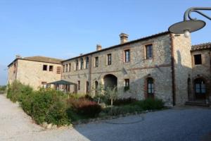 - un grand bâtiment en pierre avec un éclairage de rue devant dans l'établissement Cozy home in countryside Asciano Siena -renovated!, à Asciano