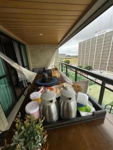 a tray of food with pots and pans on a balcony at Luxuoso Studio particular reformado no Grand Mercure in Brasilia