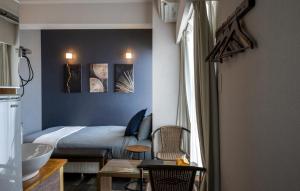 那霸的住宿－Hotel SERA LUNA -ホテル セラルナ-，卧室配有一张床和一张桌子及椅子