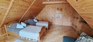 a attic bedroom with two beds in a log cabin at Cottage - Liepų Sodyba in Joniškėlis