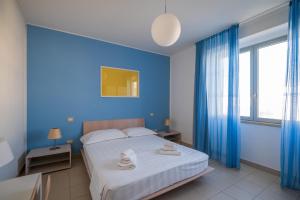 a blue bedroom with a bed and a window at Solidago Residence in Tirrenia