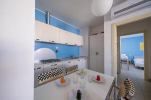 Il comprend une cuisine équipée d'une cuisinière et d'un comptoir blanc. dans l'établissement Solidago Residence, à Tirrenia