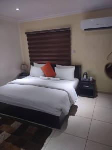 a bedroom with a large bed with two red pillows at TRENDY INN HOTEL in Lagos