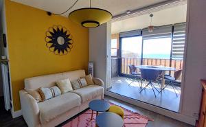 ein Wohnzimmer mit einem Sofa und einem Tisch in der Unterkunft Sausset-les-Pins, T2 vue sur mer, plage à 200m in Sausset-les-Pins
