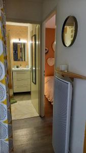 ein Badezimmer mit einem Spiegel und ein Schlafzimmer mit einem Bett in der Unterkunft Sausset-les-Pins, T2 vue sur mer, plage à 200m in Sausset-les-Pins