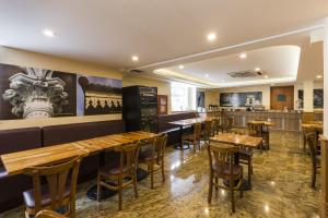 um restaurante com mesas e cadeiras de madeira em Gamboa Rio Hotel no Rio de Janeiro