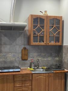 uma cozinha com armários de madeira e um lavatório em Будинок для відпочинку Dana em Berehove