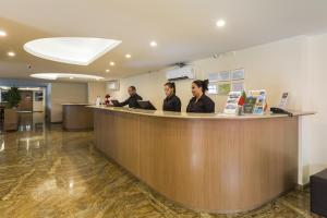 three women sitting at a reception counter in a office at Gamboa Rio Hotel in Rio de Janeiro