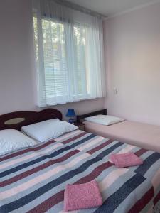 um quarto com duas camas e um cobertor listrado em Будинок для відпочинку Dana em Berehove