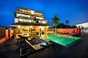 拉威海灘的住宿－Ratana Hotel Chalong，房屋前有游泳池的建筑