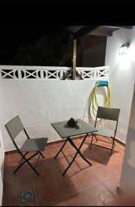 two chairs and a table on a patio at night at Casa Emma in Playa Honda