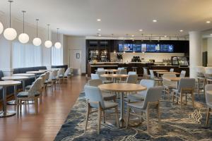 a restaurant with tables and chairs and a bar at Courtyard by Marriott Sandestin at Grand Boulevard in Destin