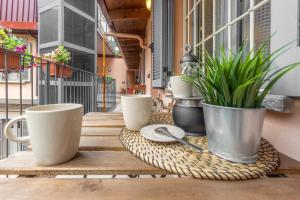 uma mesa com chávenas de café e plantas numa varanda em TAR5 -20 minutes from DUOMO- Design-Elegant em Milão