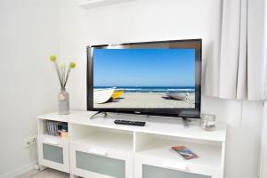 a flat screen tv sitting on a white entertainment center at Haus Prohl Whg1 in Dahme