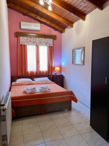 een slaapkamer met een bed met rode lakens en een raam bij Ariadni Hotel Bungalows in Skala Potamias
